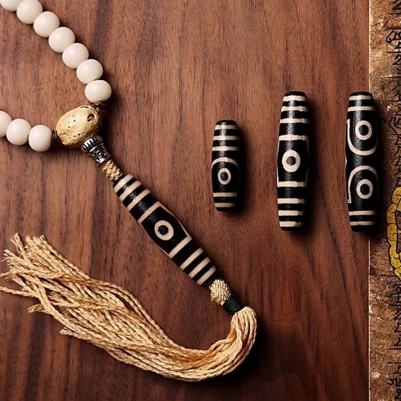 108 Mala Beads Bracelet – Dzi beads alongside cream mala on wood
