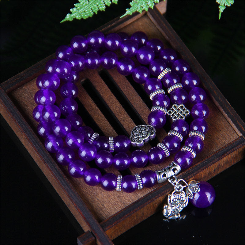 Amethyst PiXiu Bracelet – Purple beads coiled in wooden tray with silver accents