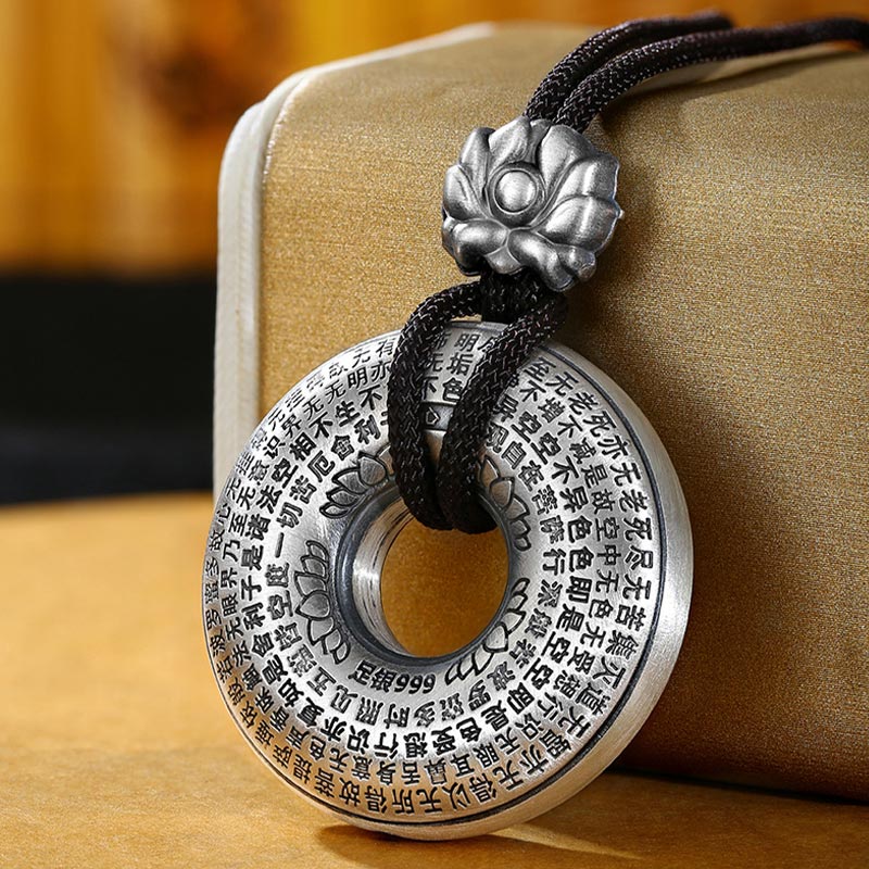Silver Heart Sutra Pendant – 999 silver bi-disc with engraved Chinese scripture and lotus bail on black cord, peace amulet