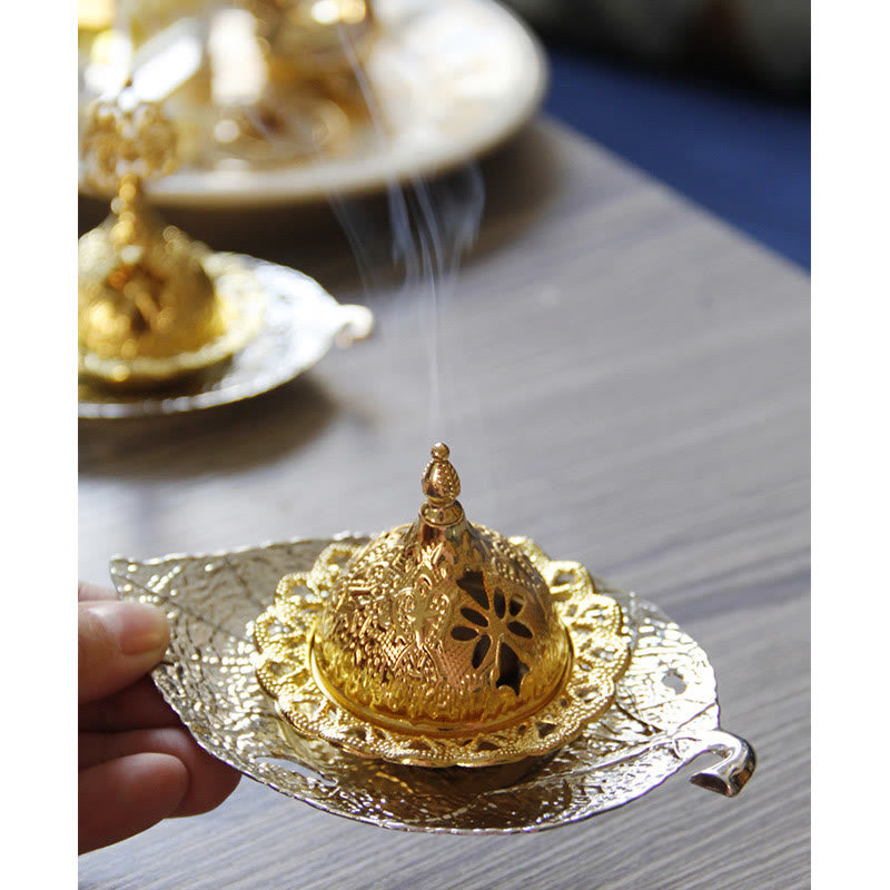 Tibetan Gold Leaf Coaster Incense Burner – Gold burner with smoke and hand on silver leaf tray, brass incense holder