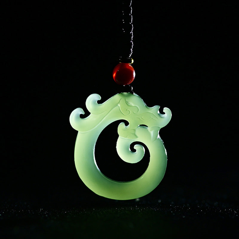 White Jade Cyan Jade Dragon Pendant – translucent white jade coiled dragon on black, luminous