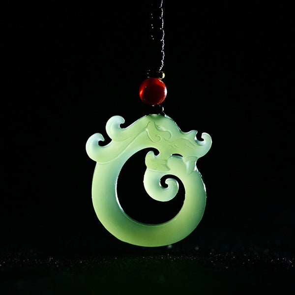 White Jade Cyan Jade Dragon Pendant – translucent white jade coiled dragon on black, luminous