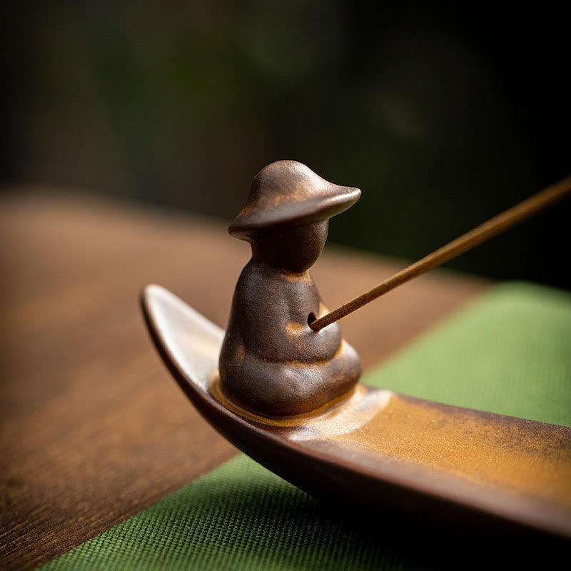 Fisherman Incense Burner – Close-up hat figure holding incense on green cloth, mindful decor