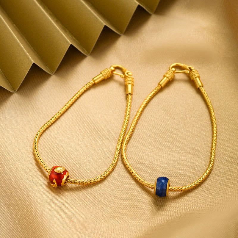18K Gold Om Mani Padme Hum Koi Fish Bracelet – two gold braided bracelets with red enamel and blue stone beads, green fan prop backdrop