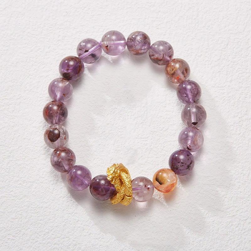 Purple Phantom Quartz Dragon Bracelet – Flat lay with natural purple phantom beads and orange accent, enchanting