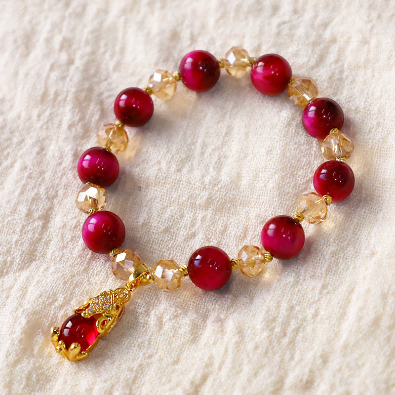 Red Tiger Eye PiXiu Bracelet – Circular layout on cream fabric with gold PiXiu pendant, feng shui