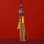 Tibetan Prayer Wheel Keychain – gold-tone prayer wheel pendant with colorful silk tassel, turquoise beads and auspicious knot charm, red background, front vertical view