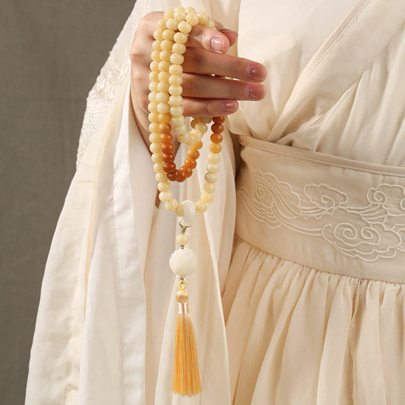 Bodhi Seed Lotus Dzi Bracelet - Mala strand held in hand wearing hanfu, gray backdrop, bodhi prayer beads