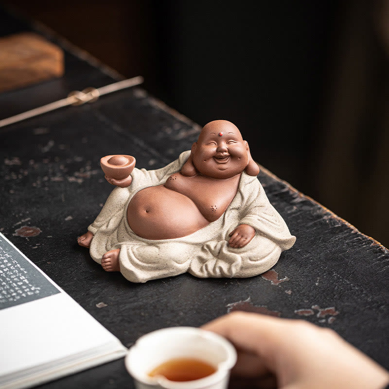 Laughing Buddha Clay Statue – statue placed on office desk with plants, modern home decoration