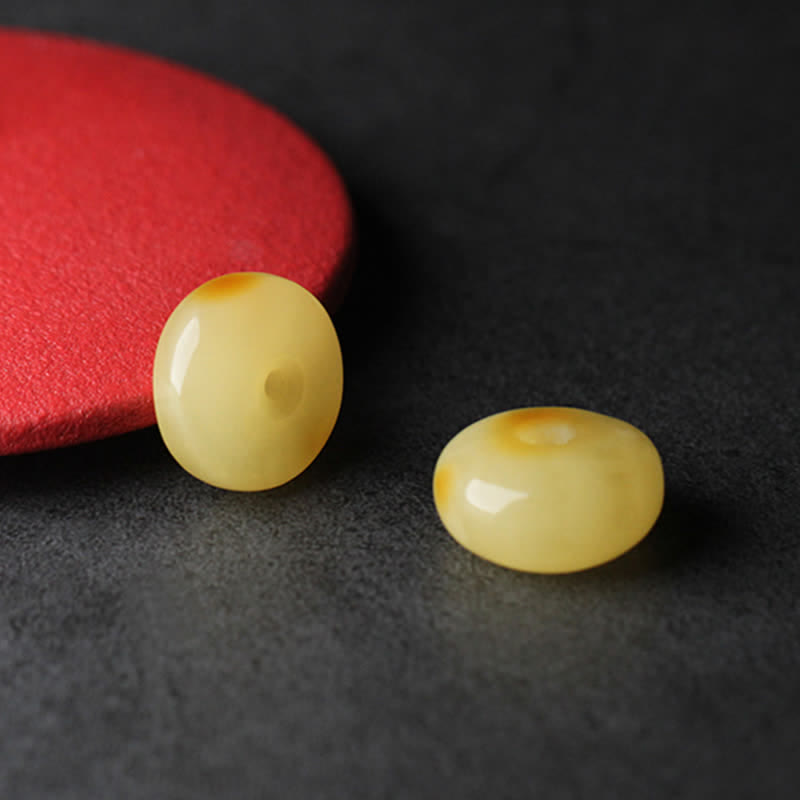 Citrine Mala Bracelet – Two natural amber peace buckle beads on dark surface with red accent