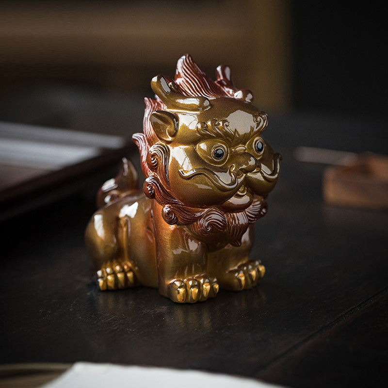 Small PiXiu Tea Pet – Gold PiXiu on dark wood surface under warm indoor lighting, wealth charm