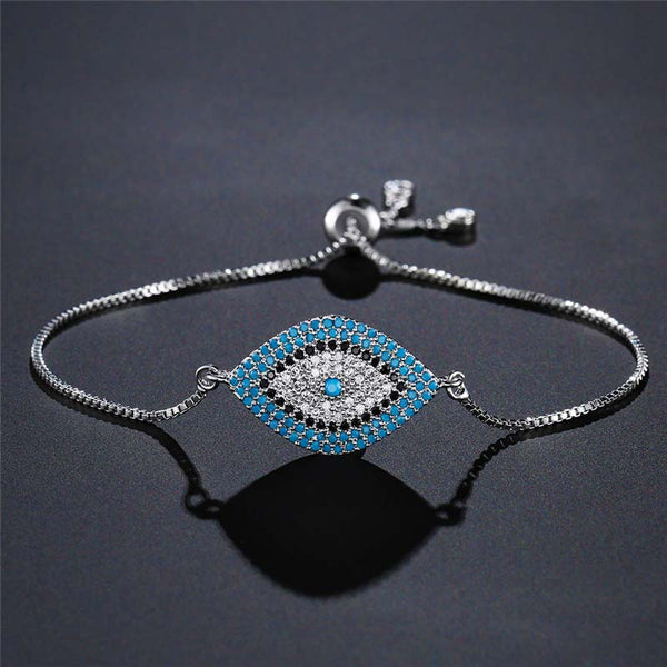 Evil Eye Healing Bracelet – Silver adjustable evil eye bracelet on charcoal textured surface, studio photo
