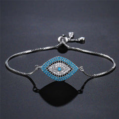 Evil Eye Healing Bracelet – Silver adjustable evil eye bracelet on charcoal textured surface, studio photo