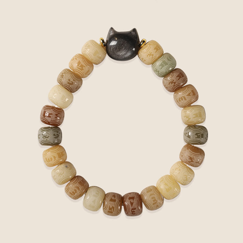 Bodhi Seed Cat Head Bracelet – Cream background view of carved barrel beads with gold-connected cat head charm, natural seed bead bracelet
