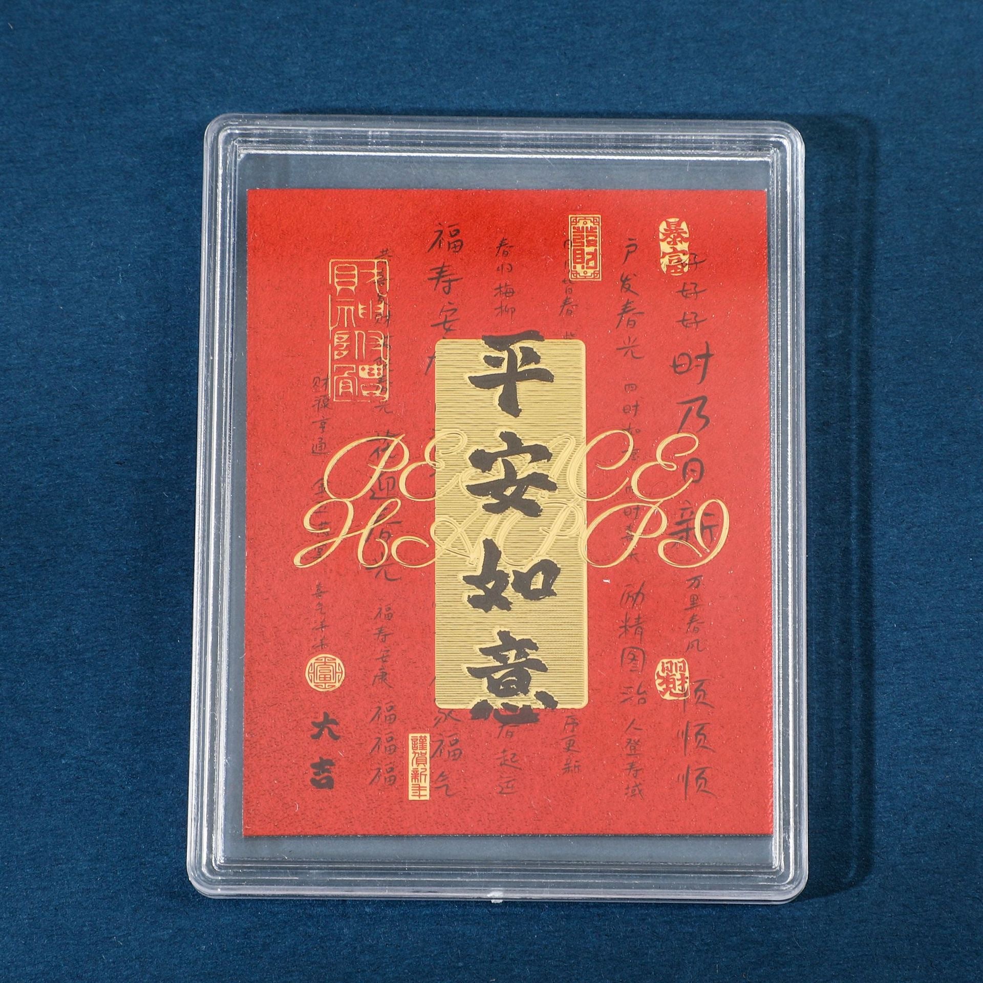 Red Peace Blessing fortune sticker in clear display case on blue background