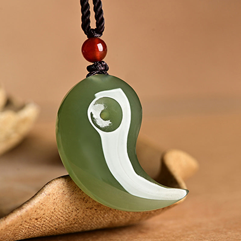 Yin Yang Jade Necklace – Sage green comma-shaped jade pendant on black braided cord, red accent bead