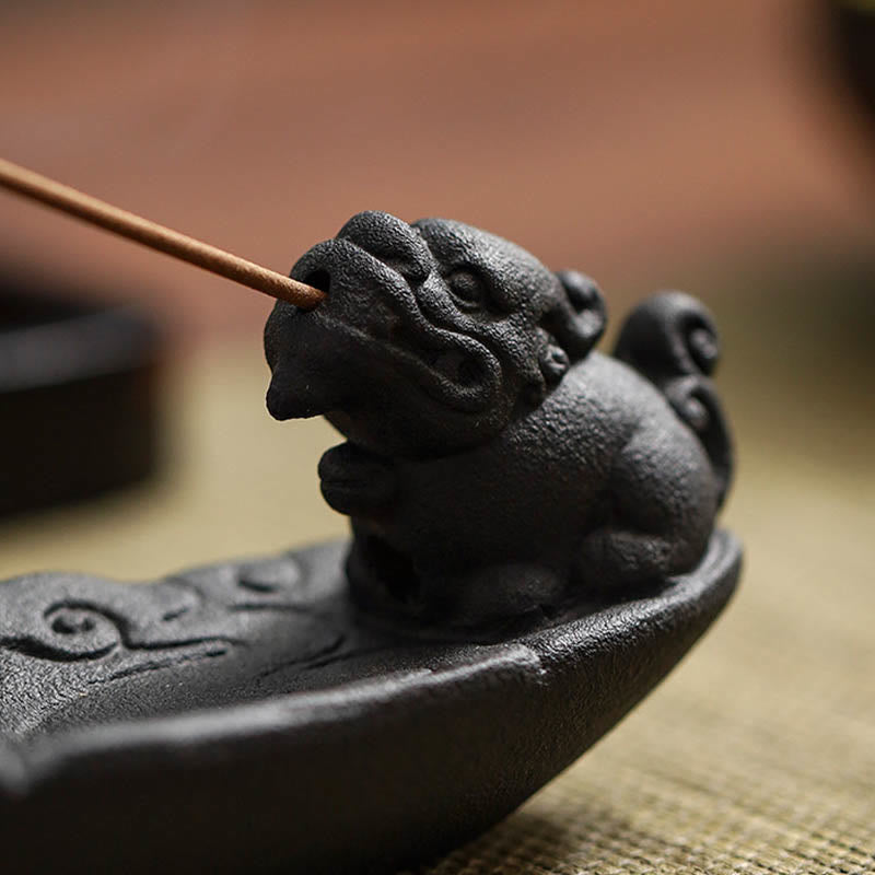 Close-up of Pixiu guardian beast holding incense in mouth, carved cloud base, warm background – ceramic incense burner sculpture