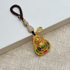 Gold filigree rotating calabash keychain with six-syllable mantra and jade gourd bead, brown cord