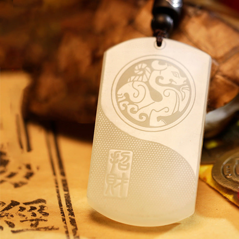 White Jade PiXiu Pendant – White jade PiXiu yin-yang pendant with brown cord over ancient calligraphy scrolls