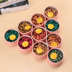 Tibetan incense cones – ten pink tubes of colorful meditation cones with yellow holders on wood, calming