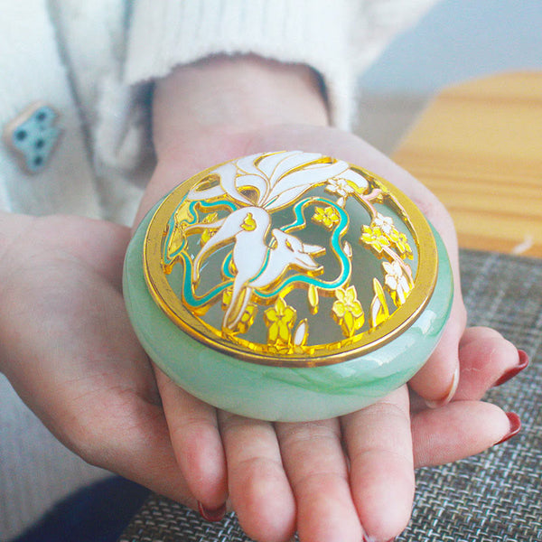 Green Nine-Tailed Fox Liuli Burner - Two hands cradling jade base with gold fox lid, crystal incense holder
