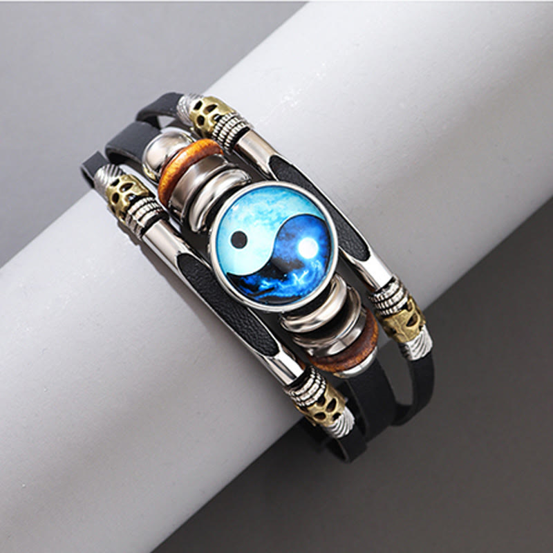 Yin Yang Leather Balance Bracelet - Blue yin-yang on black leather with skull and wood accents on stand, wrap bracelet
