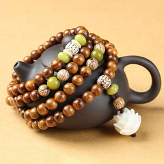 Rosewood Lotus Mala – 108 beads draped on teapot with carved white lotus pendant, protection