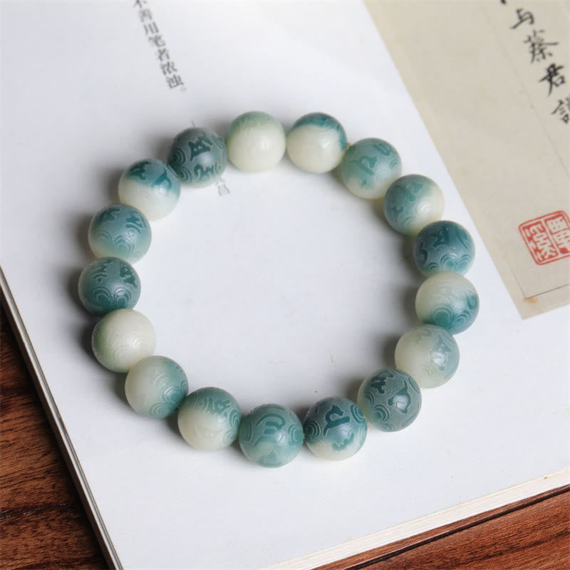 Bodhi Seed Om Mani Padme Hum Bracelet – Resting on classical book with red seal stamp, carved turquoise beads