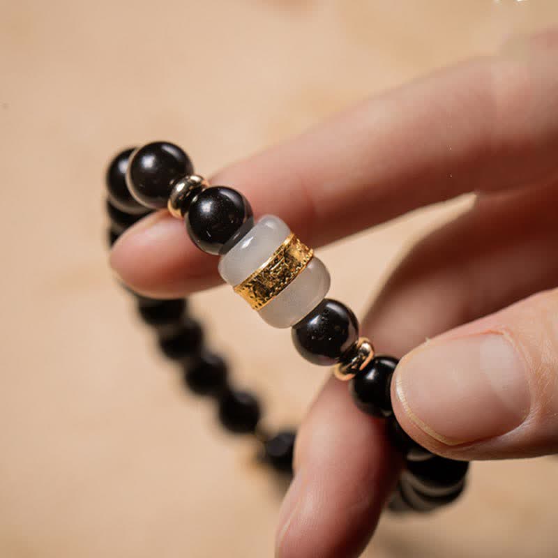 Black Obsidian Jade Bracelet – Hand-held close-up of gold-ringed jade accent bead, men's beaded bracelet