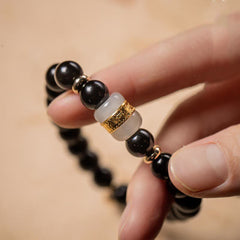 Black Obsidian Jade Bracelet – Hand-held close-up of gold-ringed jade accent bead, men's beaded bracelet