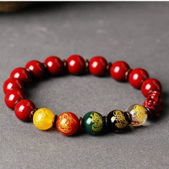 Cinnabar PiXiu Blessing Bracelet – Side view on gray showing gold-patterned multicolor beads with PiXiu