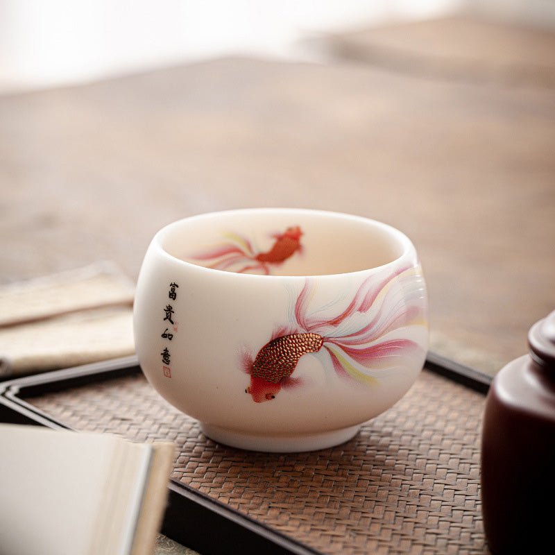 Koi Fish Porcelain Teacup - held in hand demonstrating cup size and grip, Chinese tea