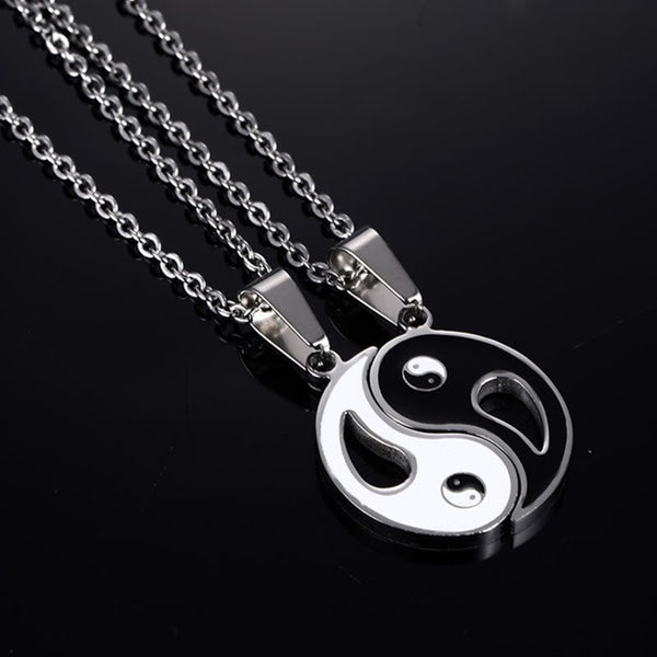 Yin Yang Pendant Couple Necklace Set - Interlocking silver and black yin-yang pendants on glossy black surface, couple nec...