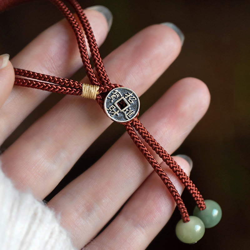 925 Silver Zodiac Natal Buddha Red String Bracelet worn on hand, antique silver Chinese coin charm with prosperity characters, pale green jade beads, gold binding wrap, lifestyle hand model shot
