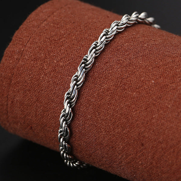 Silver Rope Bracelet – twisted chain on terracotta mandrel, dark bokeh, men's silver jewelry