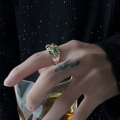 Silver PiXiu Ring – On hand holding glass with amber liquid, black background, luxury spiritual ring
