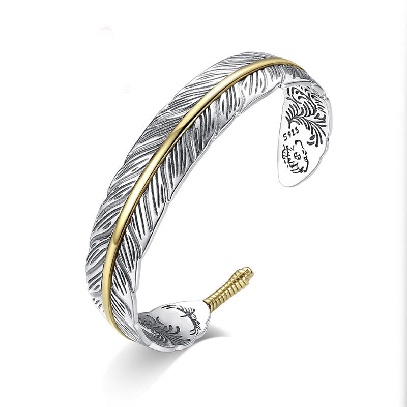 S925 sterling silver feather cuff bracelet with gold central spine, etched barb texture and decorative terminal engravings on white background