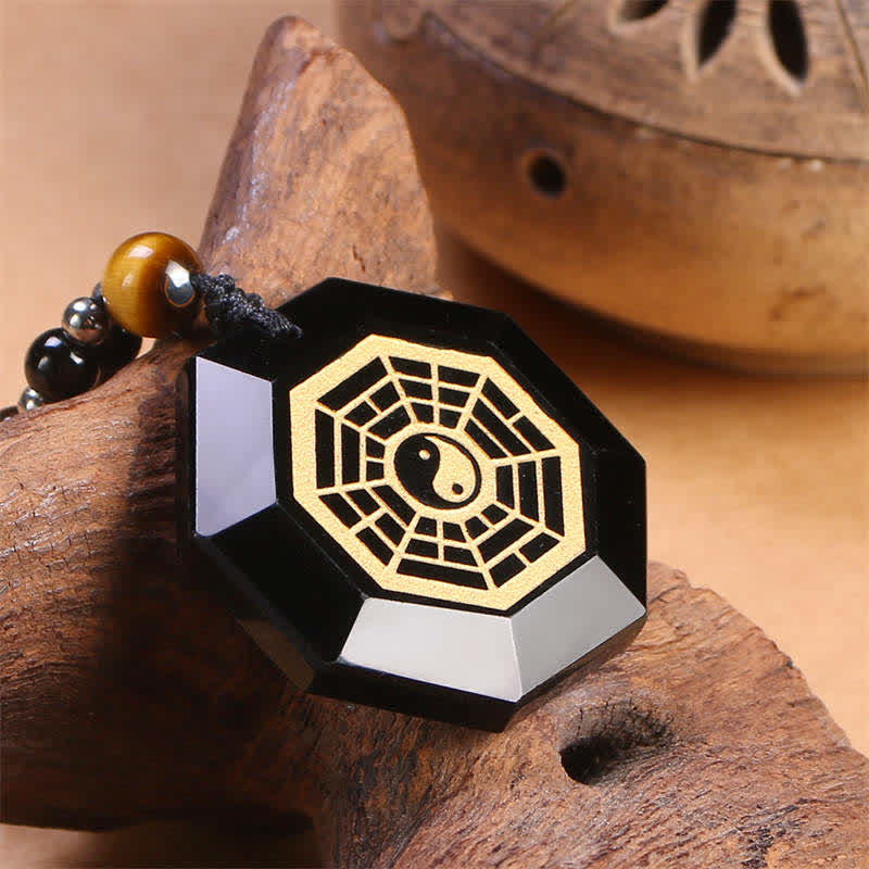 Black Obsidian Tiger Eye Bagua Yin Yang Pendant - Faceted obsidian bagua pendant with gold yin yang on natural wood, protecti