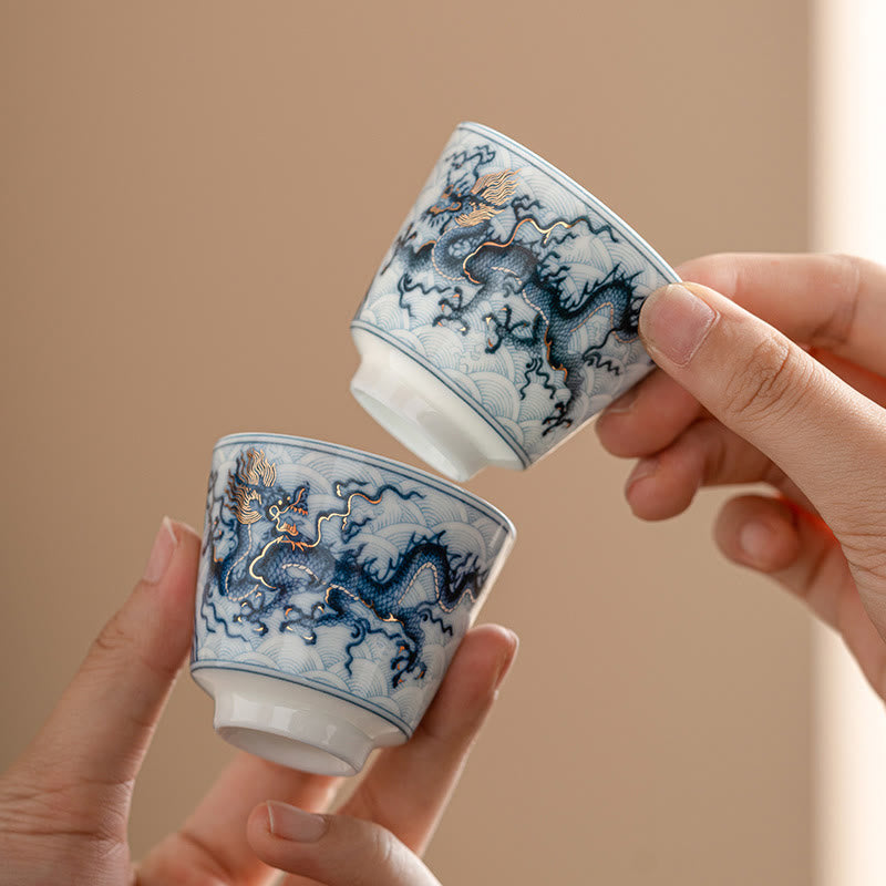 Blue & White Dragon Ceramic Teacup – pair of cups held in hands showing dragon motifs, artisanal