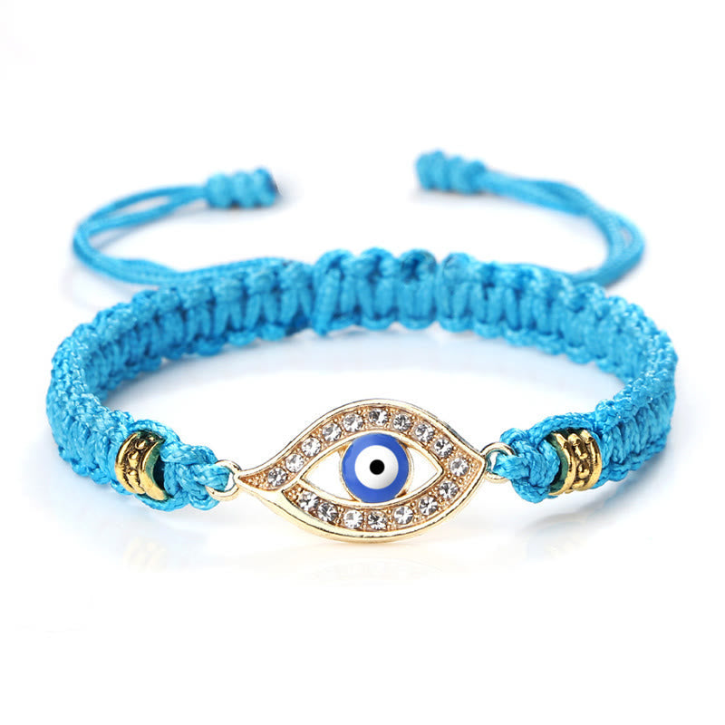 Turquoise cord evil eye bracelet with gold crystal pave evil eye charm on white background