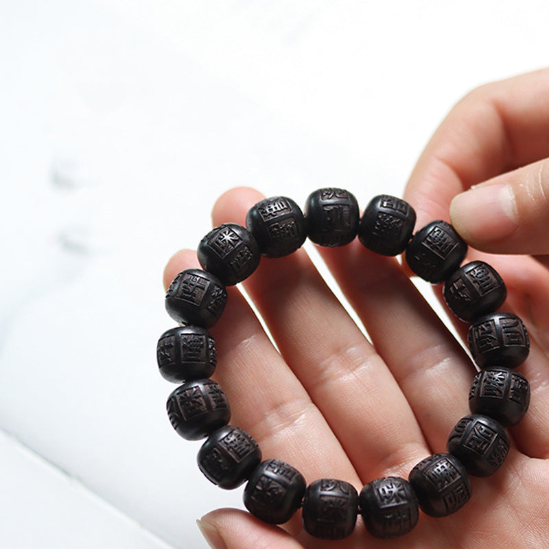 Ebony Wood Mantra Bracelet – Resting on open palm demonstrating bead size and texture, healing bracelet