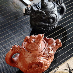 Vintage Dragon Phoenix Purple Clay Teapot – terracotta and black dragon teapot variants on striped bamboo mat, artisan craft