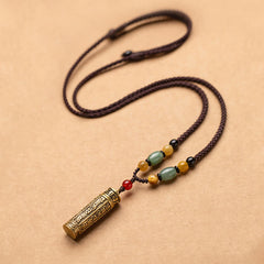 Tibetan Buddhist mantra cylinder pendant necklace with green aventurine, amber, and red carnelian beads on adjustable brown braided cord