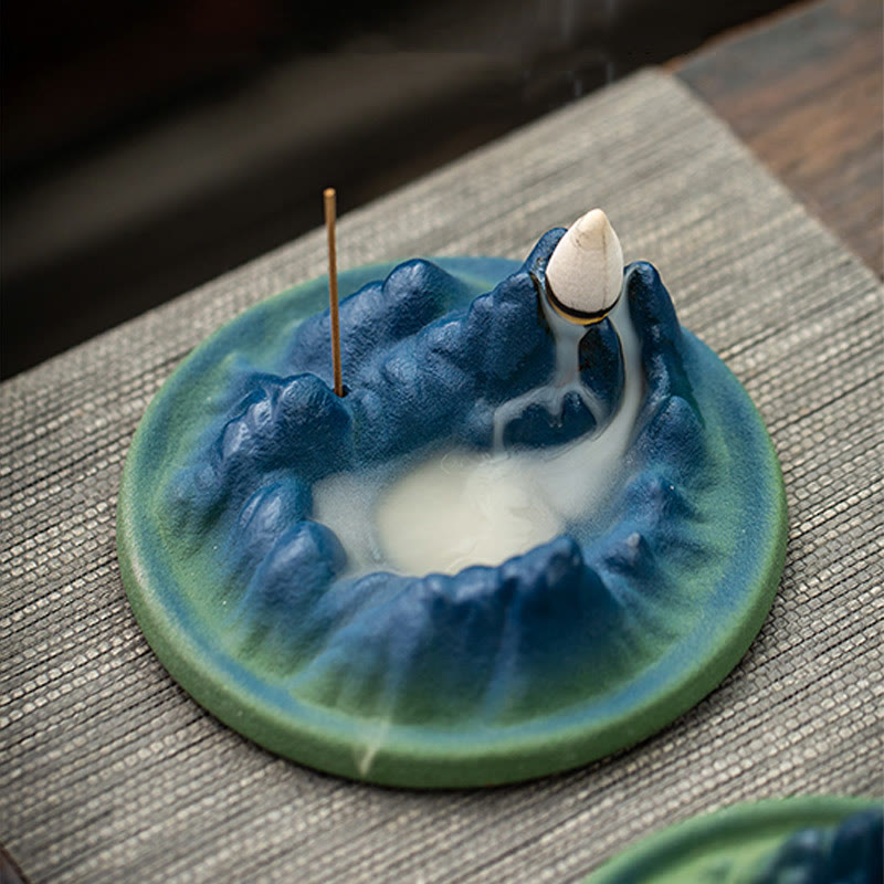 Ceramic Backflow Incense Burner – Cobalt mountain ring with white smoke pool and stick incense on gray mat, zen