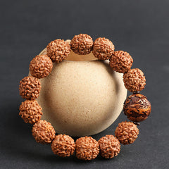 Rudraksha PiXiu Bracelet – Wrapped around beige ceramic jar, dark background, spiritual jewelry