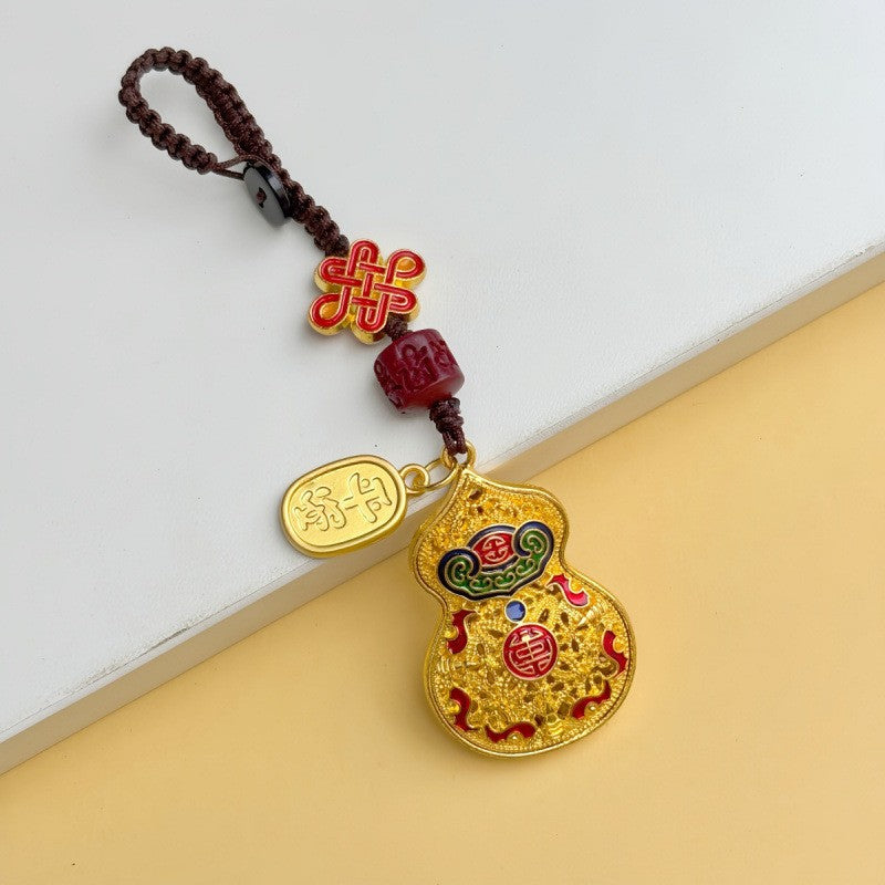 Gold filigree calabash keychain with Chinese knot and fortune plaque on brown woven cord