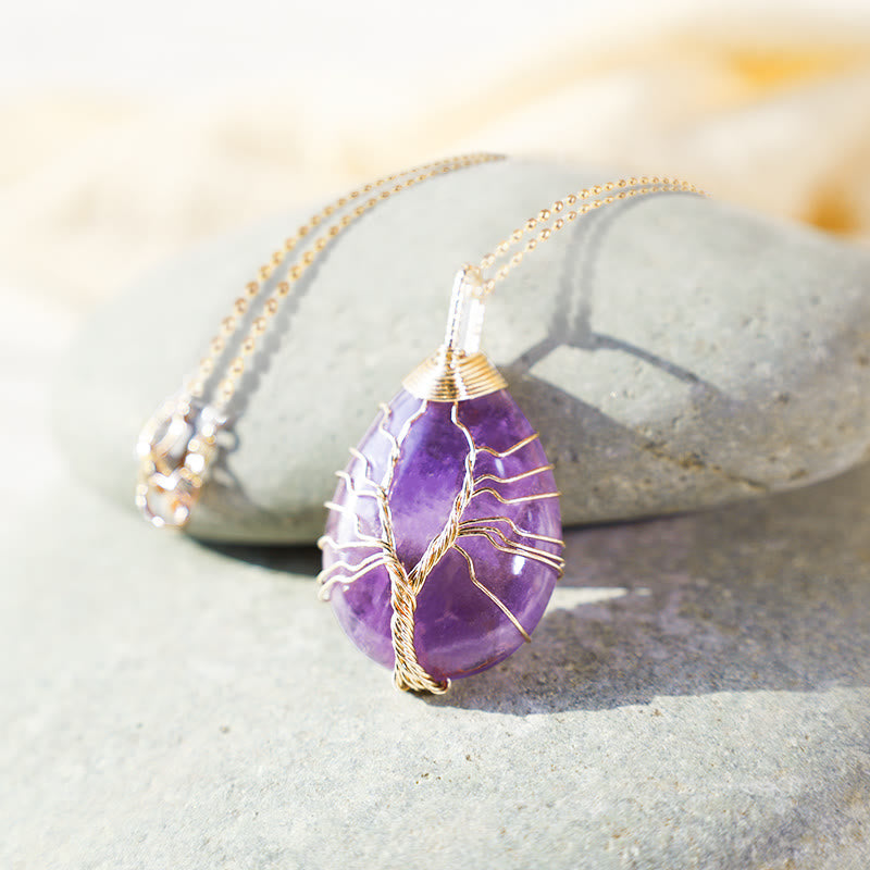 Quartz Crystal Tree of Life Necklace – amethyst pendant on gray river stones, warm bokeh, copper wire, boho