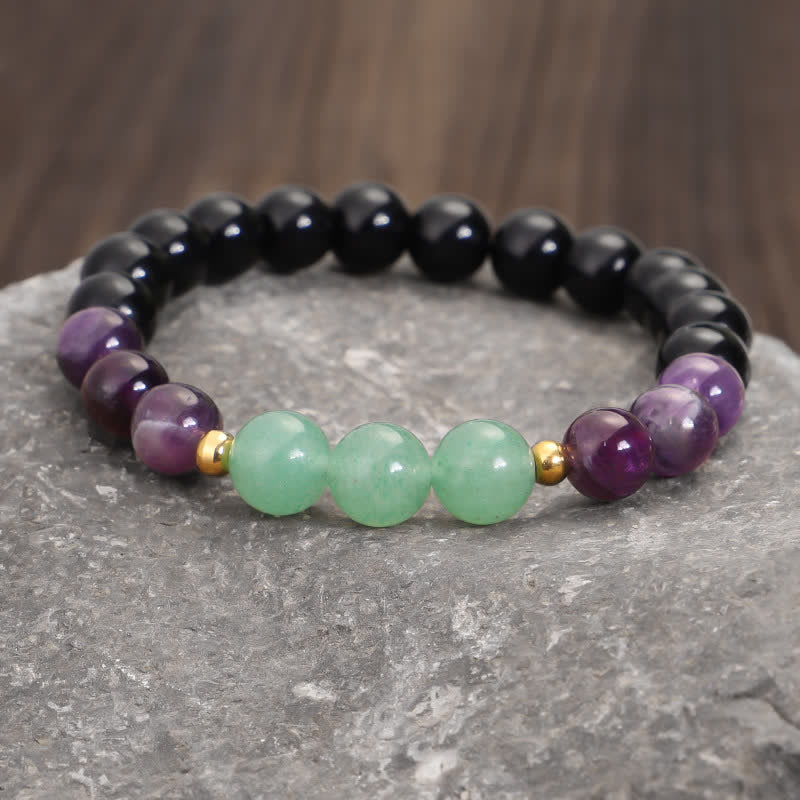 Amethyst Aventurine Lotus Mala - Gemstone stretch bracelet on gray stone with wood bokeh, healing crystals