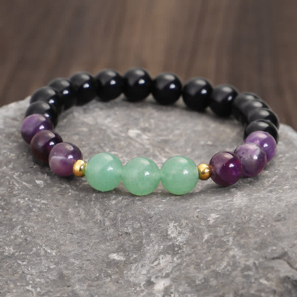 Amethyst Aventurine Lotus Mala - Gemstone stretch bracelet on gray stone with wood bokeh, healing crystals