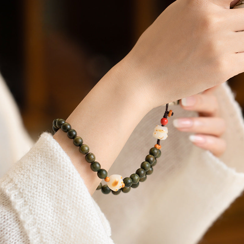 Sandalwood Cat Paw Charm – Green sandalwood bracelet-style phone charm worn on wrist with cat paw and bodhi cat figure, cute wealth luck